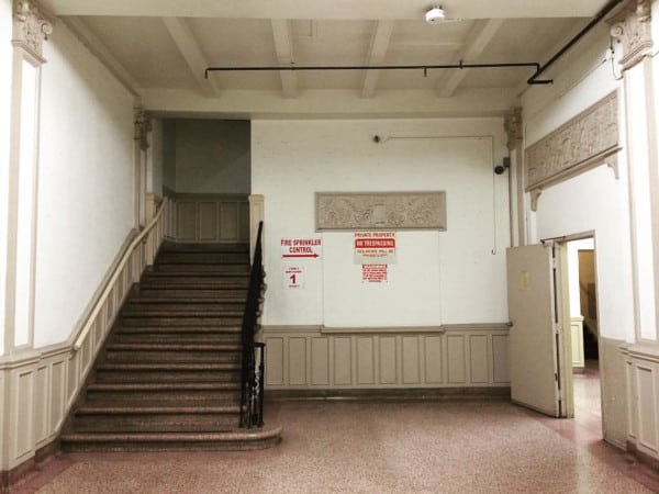 An apartment stairwell with fire sprinkler piping visible