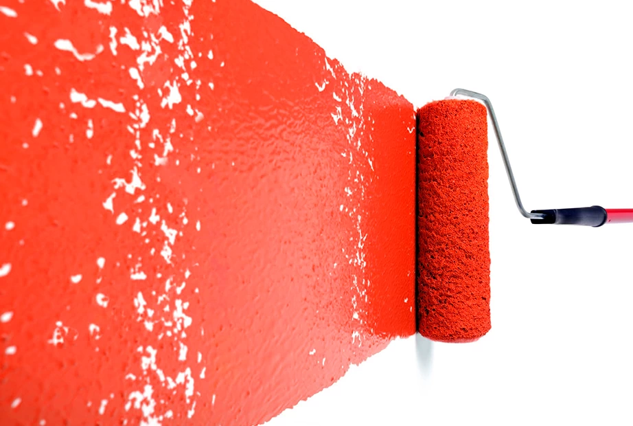 A paint roller being used to paint a wall
