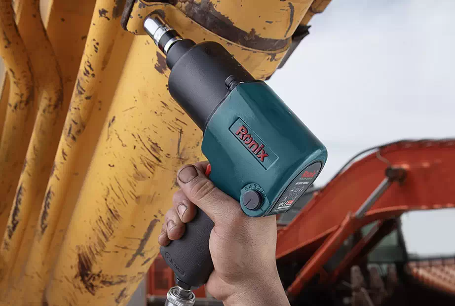 a man using a Ronix air impact wrench to tighten nuts on a pipe